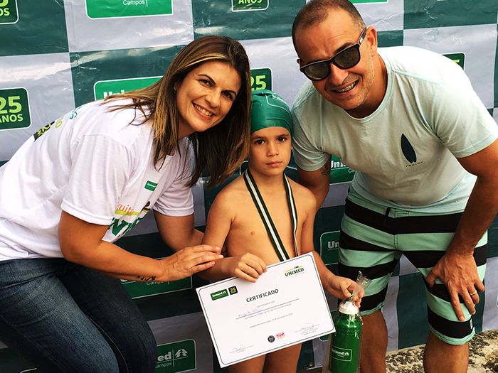 A colaboradora Gisele Arantes entregando a premiação ao seu filho Nícolas