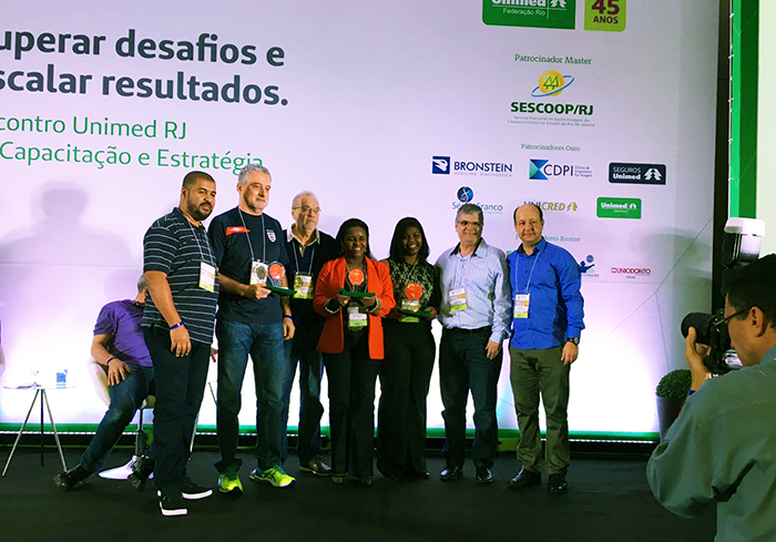 Dilceia Cunha, coordenadora da Controladoria, e presidente Elson Luiz Gatto Polo recebem o prêmio, em Angra dos Reis