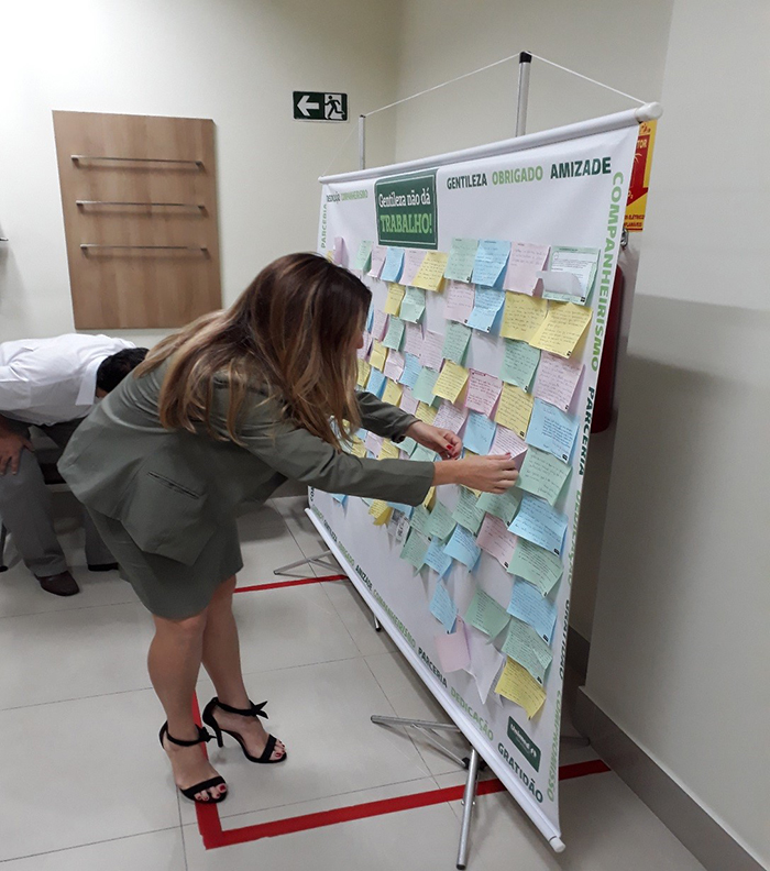 Colaboradores lendo, destacando e levando consigo o bilhete