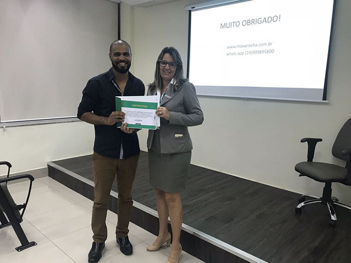 O Coach Max Rocha recebe certificado em agradecimento à palestra