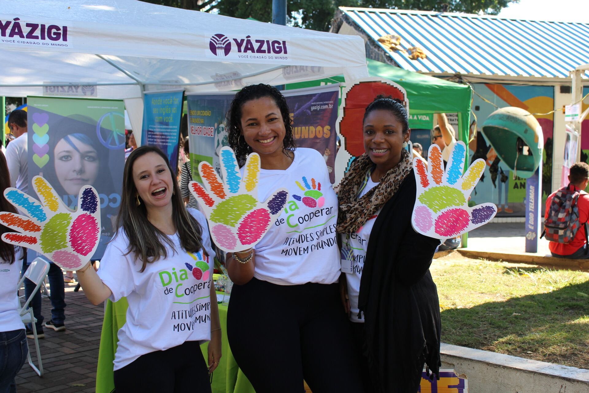  Voluntárias acenam com símbolo da ação 