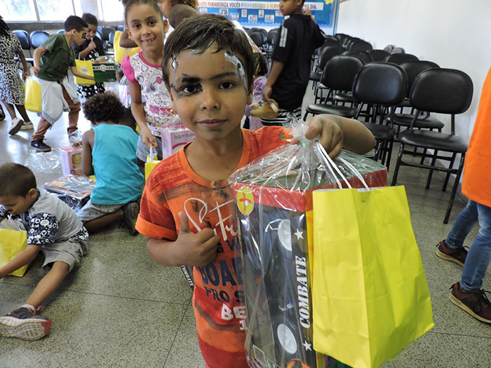  Aluno recebendo seu brinquedo na festa de Dia das Crianças