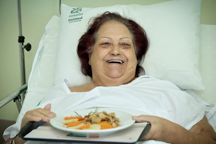 - Laudiceia Rodrigues feliz ao receber seu prato de bacalhau com batatas e cenoura.