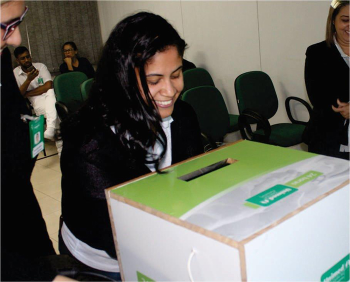 Colaboradora Claudia Moraes verificando a higienização das suas mãos em nossa caixa de luz negra