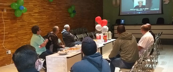 Pais assistindo aos vídeos dos filhos no auditório do hospital 