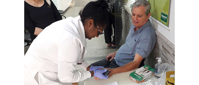  A enfermeira Liliane Rodrigues afere a glicose de Marcos Porto