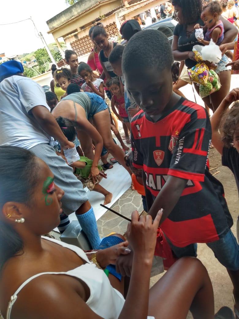 Voluntária aplicando Pintura Facial em criança 