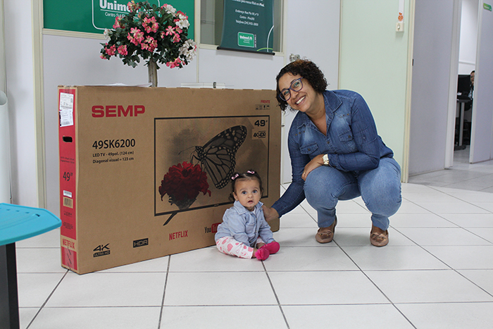  A vencedora do sorteio Josi Dias recebendo o prêmio junto com sua filha, Sara 