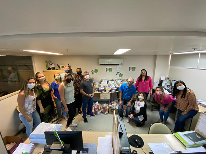 Colaboradores da área de Contas Médicas organizando as doações de cestas básicas para doação